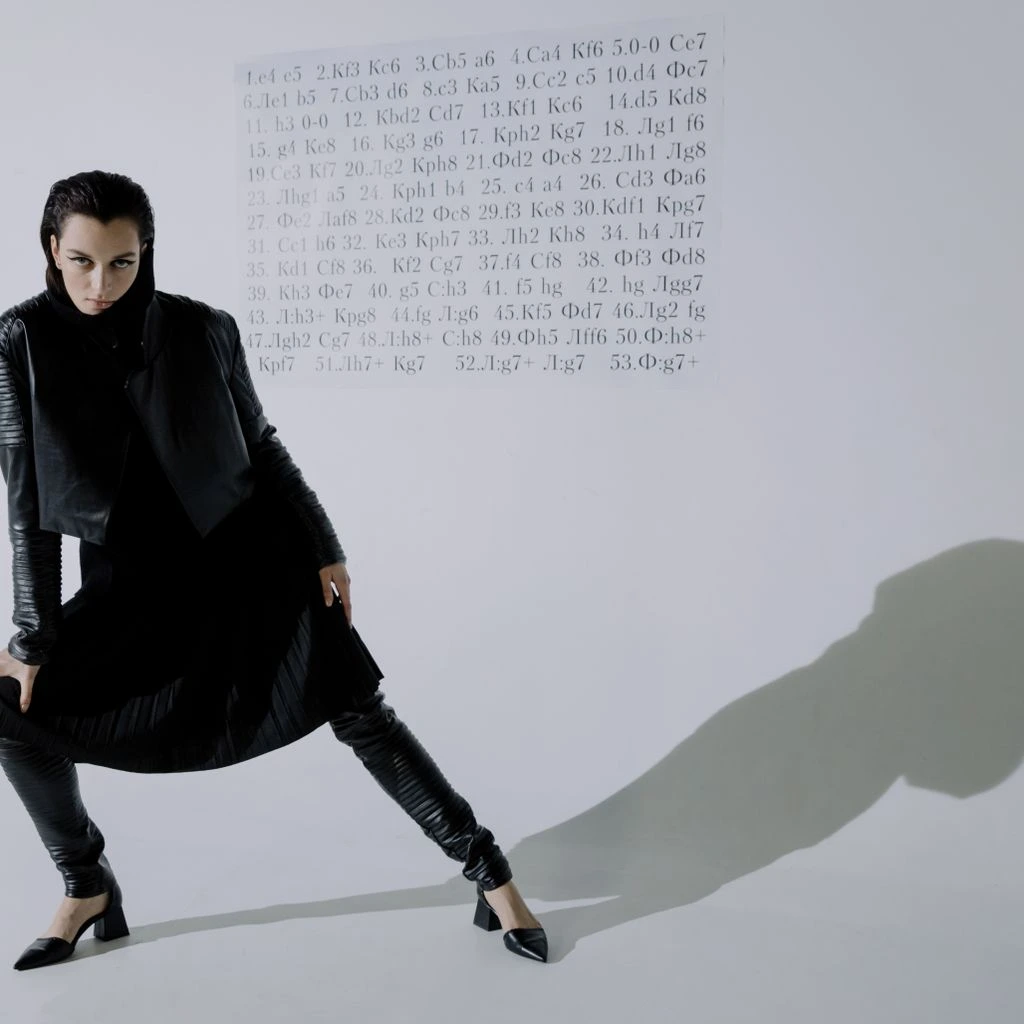 Commercial runway model walking a prêt-à-porter presentation in a minimalist white set.